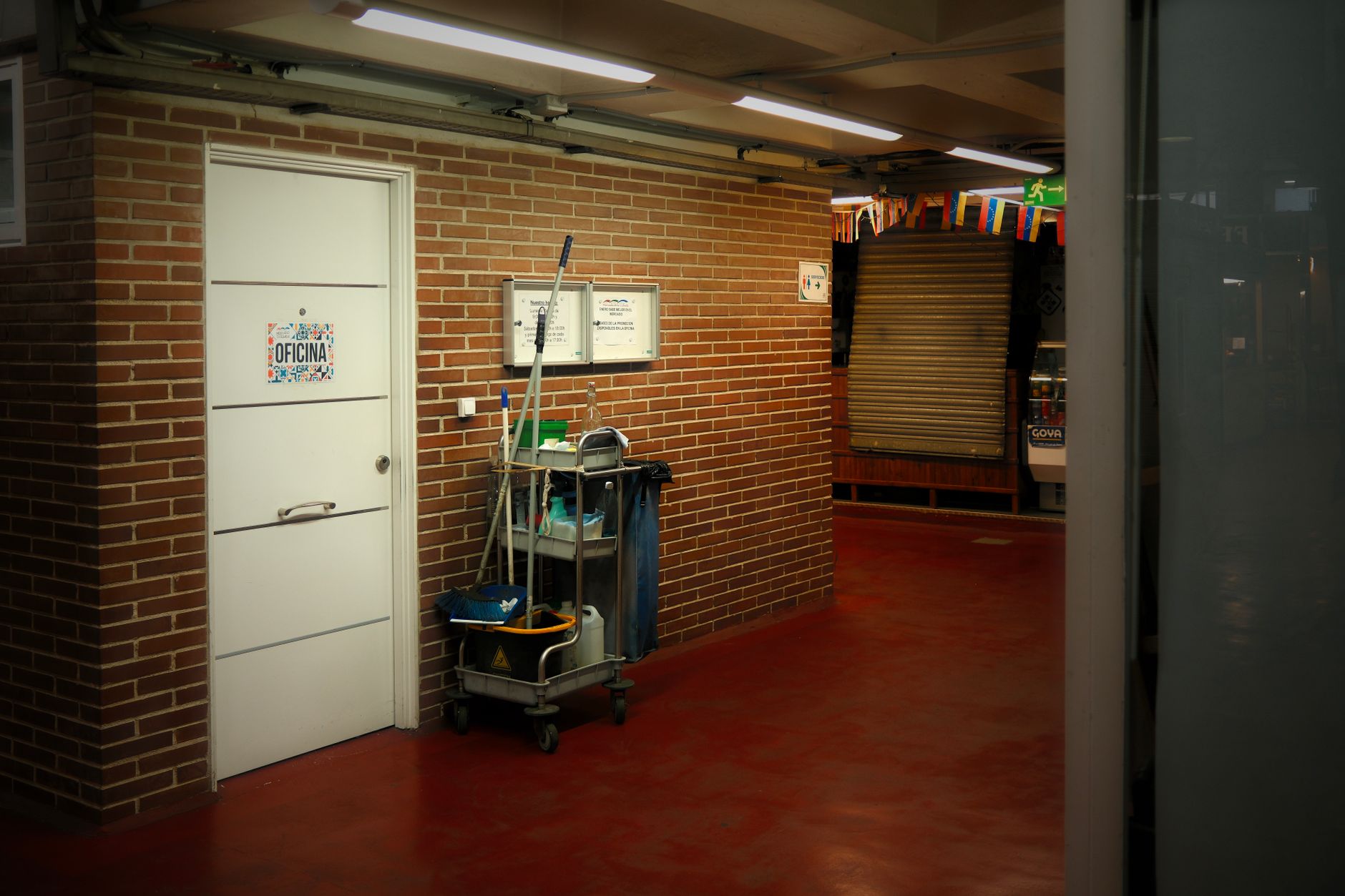 chariot de nettoyage professionnel garé dans le couloir d'un bâtiment, près d'une porte de bureau