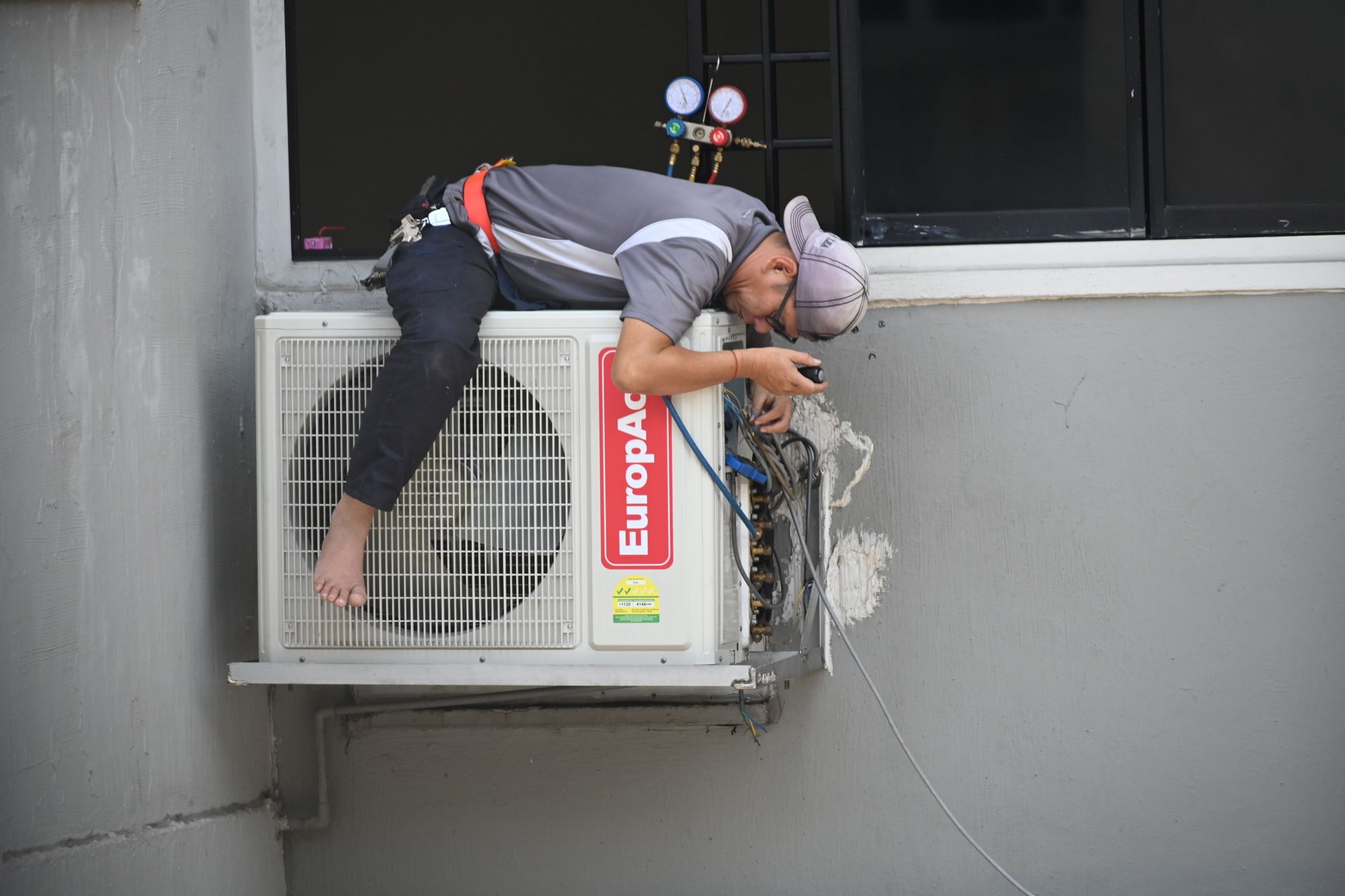 technicien en train de vérifier et entretenir une climatisation