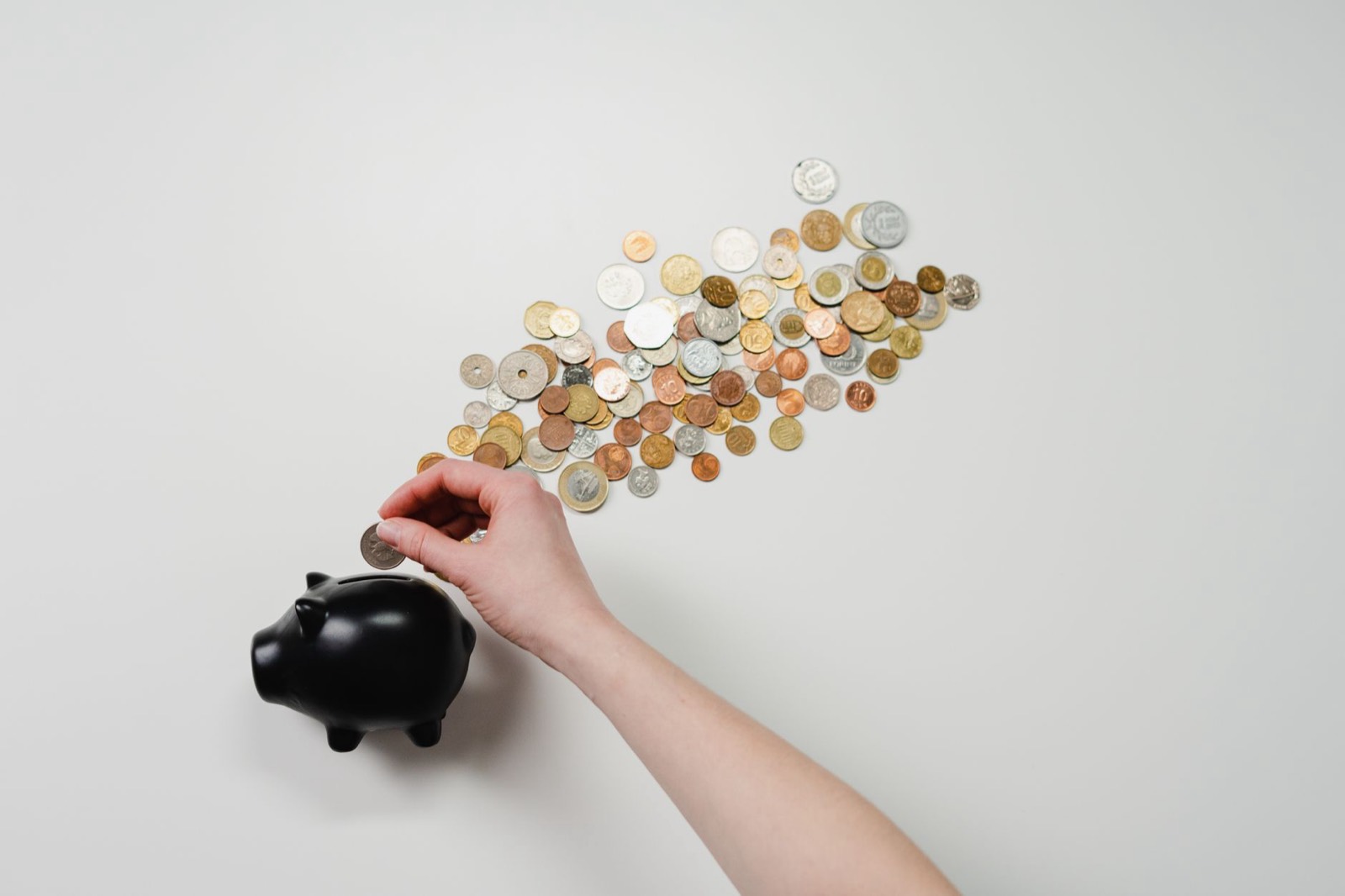 Tirelire et pièces posées sur une table, symbole d'épargne pour le budget maison