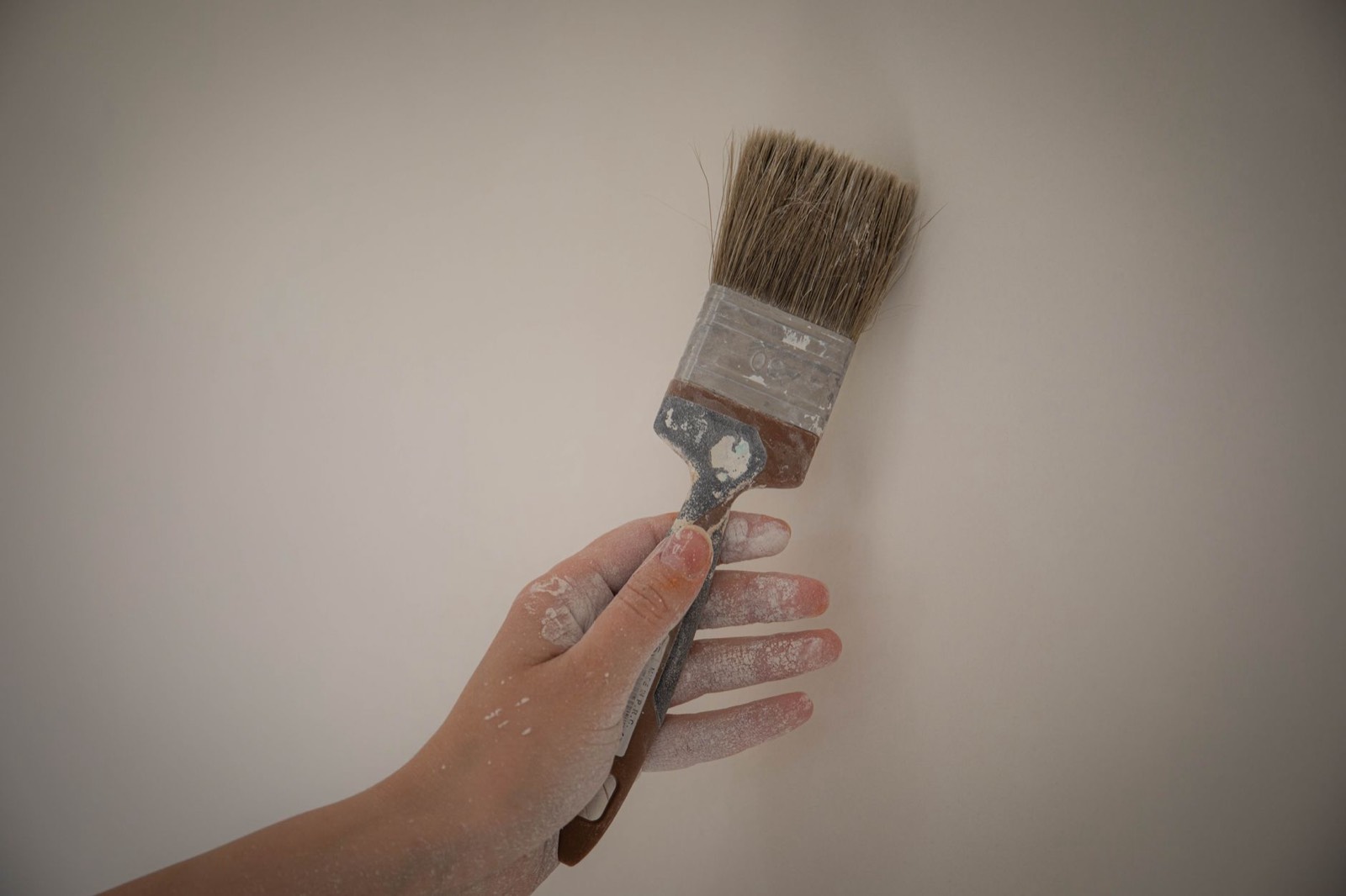 Mur en cours de repeinture avec pinceau et contraste avant-après