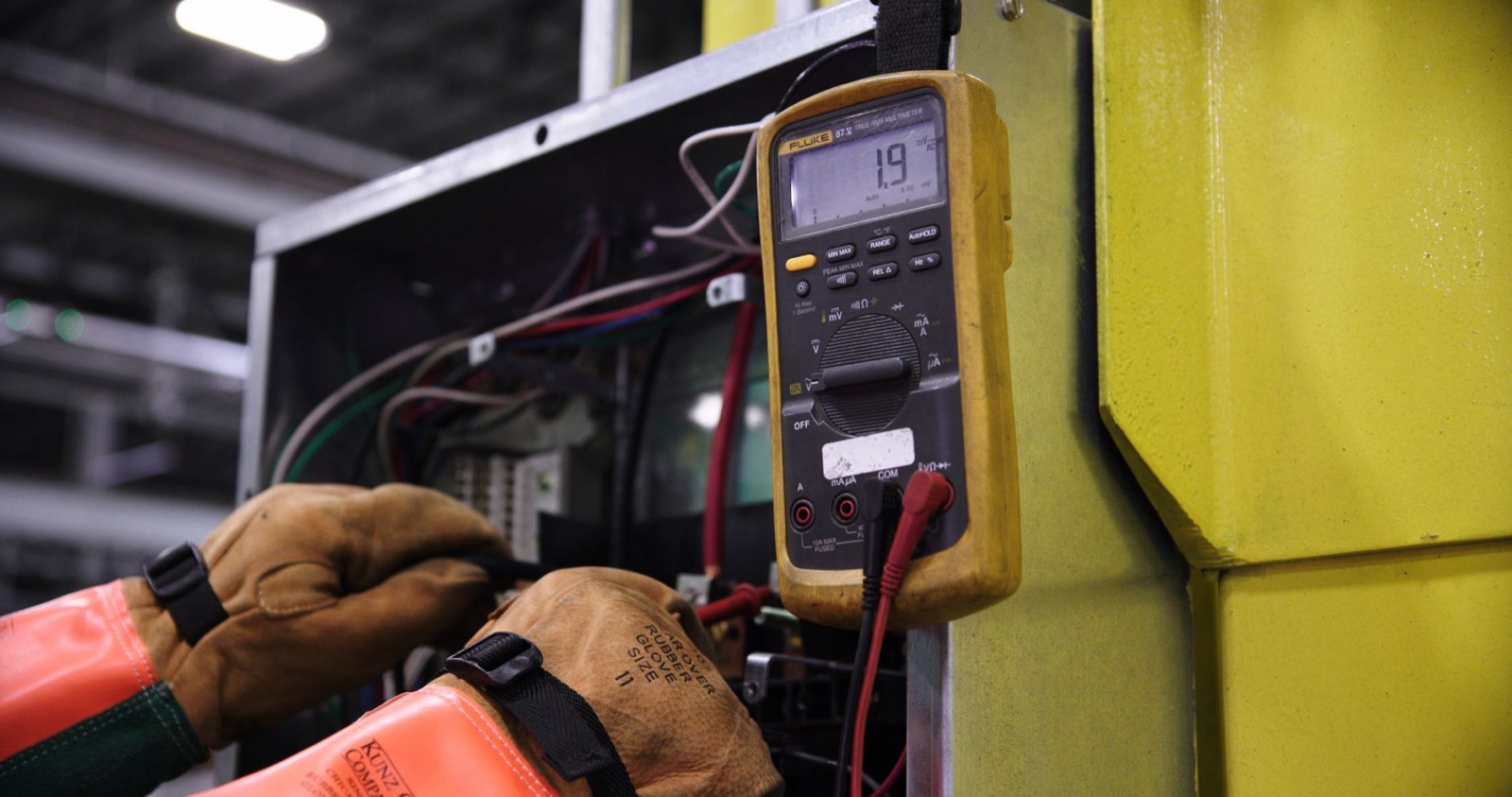 Outils d'électricien : multimètre et câbles sur un tableau électrique